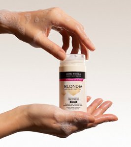 Close-up of a hand holding Blonde+ Repair System Pre-Shampoo Treatment